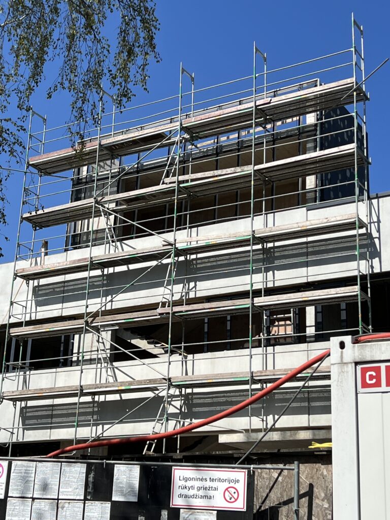 Renovacijos objektas su fasadiniais pastoliais ir turėklais